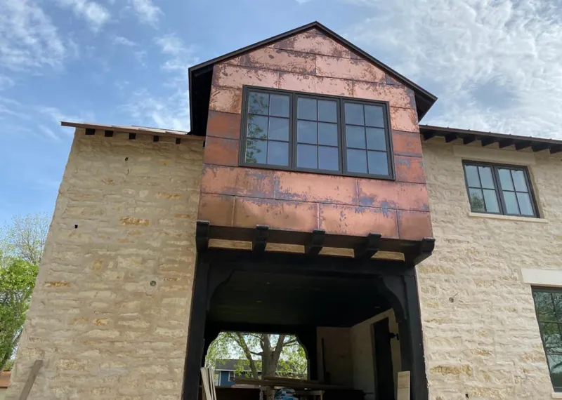Copper metal panel facade on a stone building for Skylight Installation in Silsbee